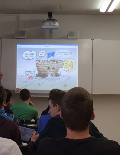 Schüler versehen die Karikaturen mit zusätzlichen Informationen und präsentieren sie anschließend mit via Apple TV.